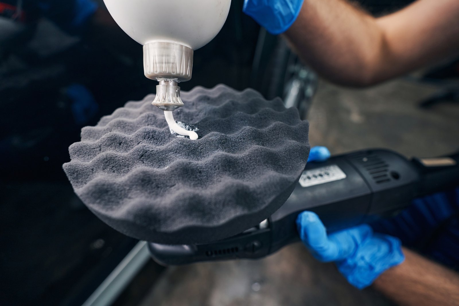 Person covering car polishing pad with cream